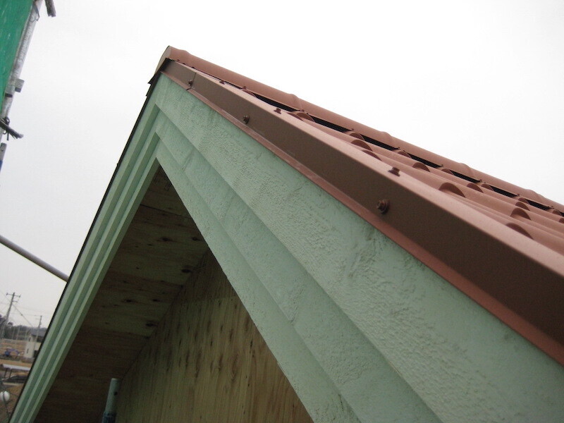 三段重ねの破風板と専用水切り材（施工中）